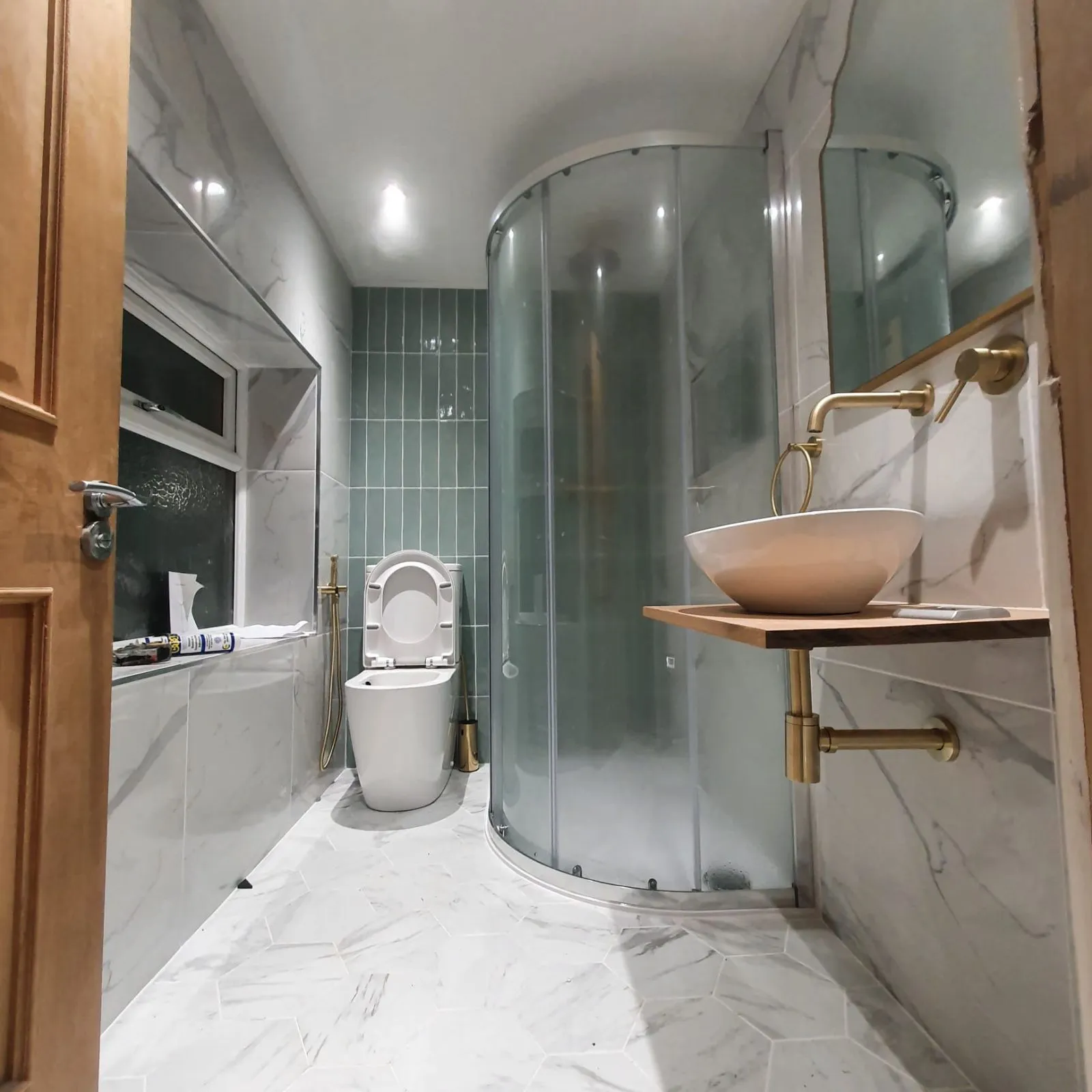 Finished bathroom with curved shower enclosure and marble-effect floor, Halifax